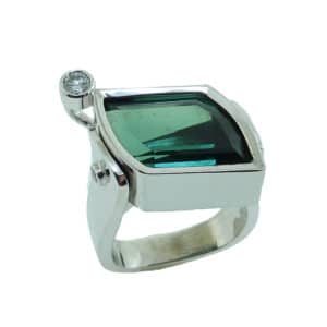19 karat white gold coloured gemstone ring by Studio Tzela bezel set with one 7.90 carat Green Tourmaline and accented with a round brilliant cut diamond, 0.14 cttw, SI2, H/I and 2 bezel set round brilliant cut diamonds, 0.04cttw, SI.