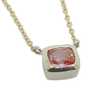 14k white gold bezel set 0.439ct pink sapphire with a 14k yellow gold 18" light cable chain.