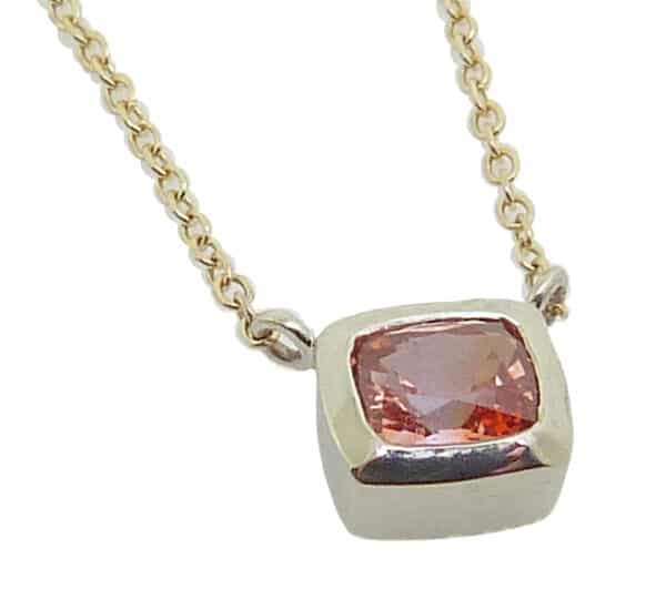 14k white gold bezel set 0.439ct pink sapphire with a 14k yellow gold 18" light cable chain.