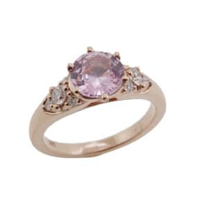 14 karat rose gold ring featuring a 1.19ct Blush sapphire and 8 = 0.25cttw round brilliant cut diamonds. 