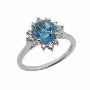 14K White gold coloured gemstone halo ring set in the centre with a round blue topaz, 1.494 carat and accented in the halo with round brilliant cut diamonds 0.24 total carat weight, H/I, SI1-2.