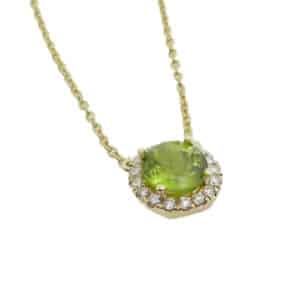 14K yellow gold halo pendant set with a 0.999ct peridot and accented with 17 = 0.13cttw H/I, SI1-2, round brilliant cut diamonds.