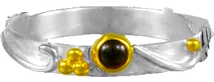 Sterling silver ring bezel set with a rhodolite garnet. This size 6 ring is accented with 22 karat yellow gold vermeil. This stacking ring is part of the Michou Collection.