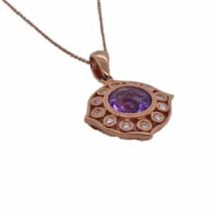14 karat rose gold pendant on a 16" cable chain set with a 1.19 carat round amethyst and in the halo with twelve round brilliant cut diamonds totaling 0.14 carats, G/H, VS-SI.