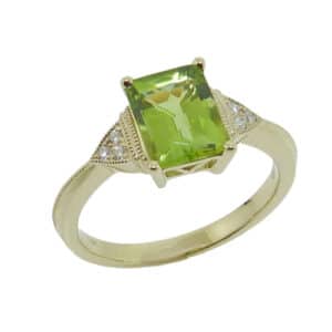 14K yellow lady's coloured gemstone knife edge ring with milgrain details set with 1.55 carat radiant cut peridot and accented with six pave round brilliant cut diamonds, 0.05 total carat weight.