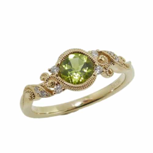 14K yellow gold ring by Ancora Designs bezel set in the centre with one 0.45 carat round peridot and accented on the band with eight round brilliant cut diamonds totaling 0.07 carat. This ring has pretty filigree and milgrain details giving it an antique, feminine style.