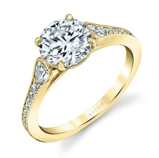14K Yellow gold Sylvie Collection solitaire engagement ring known as "Esmeralda" set in the centre with a 0.75 carat CZ and accented on the tapering milgrain band with 0.32 total carat weight pave set round brilliant cut diamonds, G/H, VS-SI. Available in 14K gold, 18K gold, or platinum. This ring can be made in any combination of white, pink or yellow gold and can be customized to accommodate different size and shape diamonds, by special order. Priced without a center gemstone. Let us find you the perfect center that fits your tastes and budget!