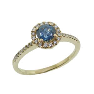 14K Yellow gold coloured gemstone lady's ring set with 0.60 carat Montana sapphire and accented on the halo and band with 0.13 total carat weight round brilliant cut diamonds.