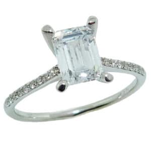 14K White gold solitaire engagement ring set with a 7x5mm emerald cut CZ and accented on the band with 18 round brilliant cut diamonds, 0.13cttw.
