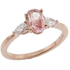 14 karat rose gold coloured gemstone ring claw set in the centre with one certified 1.03 carat oval Padparadscha sapphire and accented with two pear shaped diamonds totaling 0.23 carats, G/H, SI1.