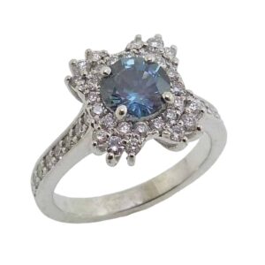 14K White gold custom lady's ring set with a 1.08 carat blue/green sapphire and accented in the halo with 44 round brilliant cut diamonds, 0.50 total carat weight, G/H, SI1.
