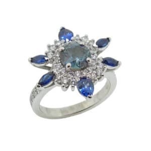 14K White gold custom lady's ring set with a 1.08 carat blue/green sapphire and accented in the halo with 4 marquis sapphires, 0.392 total carat weight; 2 pear sapphires, 0.45 total carat weight; 44 round brilliant cut diamonds, 0.50 total carat weight, G/H, SI1.