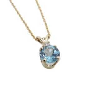 14K yellow gold pendant set with 0.95 carat round blue topaz and 0.049ct H SI1-2 round brilliant cut diamond.