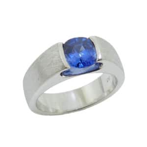14K White gold lady's ring with stainless texture channel set with a 1.13 carat cushion cut blue sapphire.