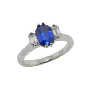 14K white gold ring set with one 0.83 carat blue sapphire and two emerald cut diamonds totaling 0.27 carats, F-G, VS.