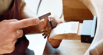 jeweller filing a ring on jewellers bench