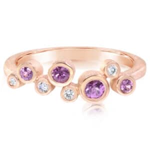 14K rose gold lady's bubble with sandblast finish ring bezel set with four purple garnets totaling 0.32 carats and four round diamonds totaling 0.052 carats, H-I, SI2.