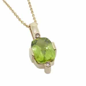 Lady's 14K yellow gold pendant set with a 1.93 carat checkerboard antique cushion peridot and accented with 2 very good cut round brilliant cut diamonds, totaling 0.024 carats, H, SI1-2.