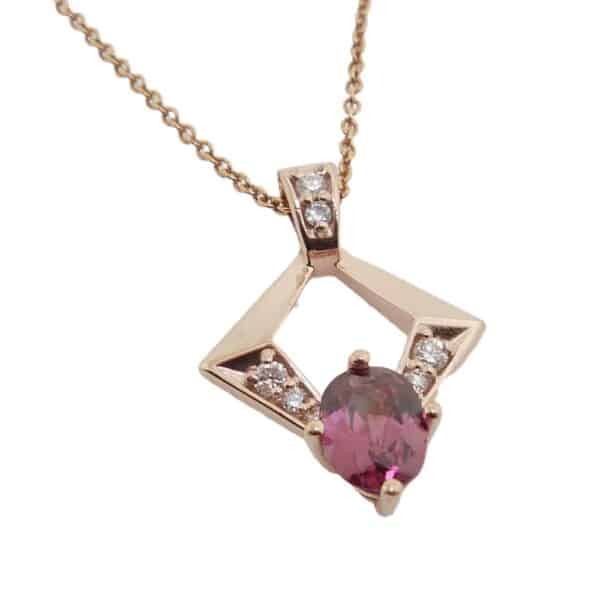 10K Rose gold pendant set with eight round brilliant cut diamonds, 0.105 total carat weight, H, SI1-2 and a 0.809ct rhodolite garnet.