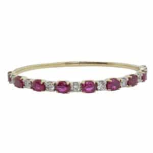 14K Yellow and white gold bracelet claw set with 1.85cttw round brilliant cut diamonds, J/K, SI, very good cut and 6.36cttw oval ruby's.