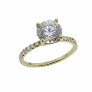 14K Yellow hidden halo solitaire engagement ring set with a round brilliant cut 1.5ct CZ and accented on the band with 20 claw set round brilliant cut diamonds, 0.27cttw and on the hidden halo 12 round brilliant cut diamonds, 0.05cttw. Available in 14K gold, 18K gold, or platinum. This ring can be made in any combination of white, pink or yellow gold and can be customized to accommodate different size and shape diamonds, by special order. Priced without a center gemstone. Let us find you the perfect center that fits your tastes and budget!