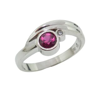Lady's 14K white gold bezel set with 0.328 carat rubellite and accented with bezel set 0.013 carat SI round brilliant cut diamond.