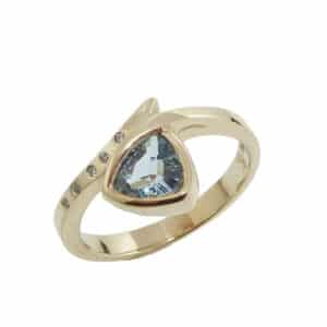 Lady's 14K yellow gold ring set with 0.406 carat trillion aquamarine and accented with 5 round brilliant cut diamonds, totaling 0.02 carats, G-H, SI.