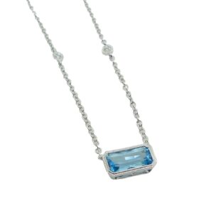 14K White necklace bezel set with a 1.01 carat emerald cut blue topaz and accented on the chain with bezel set diamonds, 0.10cttw.