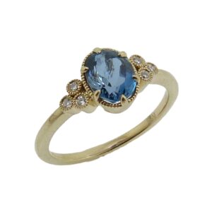 14K Yellow gold lady's ring set with 0.993 carat oval aquamarine and accented with 6 round brilliant cut diamonds totaling 0.05 carat, G-H, SI.