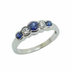 14K White gold lady's ring semi-bezel set with three round blue sapphires totaling 0.32 carats and two round diamonds totaling 0.18 carats, G/H, SI1.