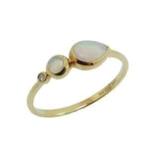 14K Yellow gold lady's ring bezel set with a 0.01 carat round brilliant cut diamond and 2 opals, 0.35 total carat weight.