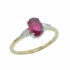 14K Yellow and white gold lady's 3 stone ring set with a 0.85 carat oval ruby and two pear shape diamonds, 0.12 total carat weight.