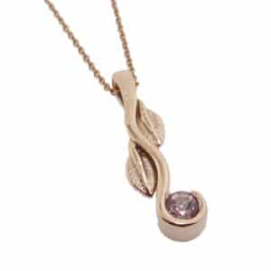 14K Rose gold custom pendant with leaf accents semi bezel set with a 4mm lotus garnet.