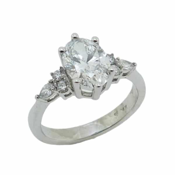 14K White gold engagement ring set with a 1.43 carat, D, VS1 oval lab grown diamond. Accented on the sides with four round brilliant cut, lab grown diamonds, 0.19 total carat weight, E/F, VS and two pear shape lab grown diamonds, 0.09 total carat weight, E/F, VS.