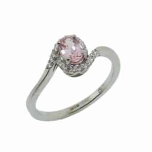 14K White gold lady's bypass halo style ring set in the centre with one 0.424 carat oval Padparadscha sapphire accented with twenty two claw set round brilliant cut diamonds totaling 0.10 carats H, SI1-2.