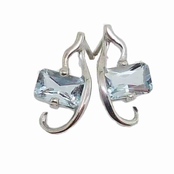 14K White gold stud earrings set with two rectangle aquamarines totaling 1 carat and round brilliant cut diamonds totaling 0.04 carats.