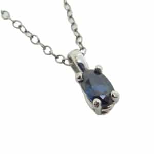 14K White gold pendant set with one 0.65 carat blue oval sapphire.