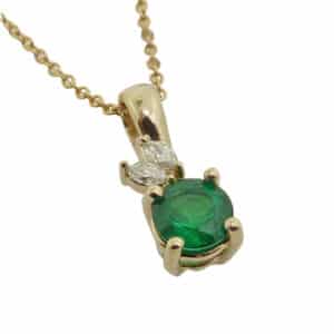 14K Yellow gold pendant set with one 0.557 carat round emerald and two marquis shaped diamonds totaling 0.073 carats, SI1, G/H.