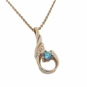 14K Rose gold pendant set with one 0.185 carat round blue zircon and five round brilliant cut diamonds totaling 0.02 carats, SI1-2, H.