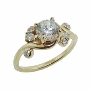 14K Yellow gold custom bypass style engagement ring set in the centre with a 0.75 carat CZ and accented with 6 claw and bezel set round brilliant cut diamonds, 0.225 total carat weight, G/H, SI.