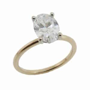 14K Yellow and white gold solitaire hidden halo engagement ring set in the centre with a 1.78 carat oval lab grown diamond, E, VS1 and accented in the hidden halo with twenty round brilliant cut lab grown diamonds, 0.05 total carat weight, E/F, VS-SI.