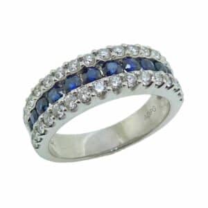 14K White gold band channel set in the centre with twelve round blue sapphires, totaling 0.75 carat, and accented on each side with thirty-two very good cut, round brilliant cut diamonds totaling 0.64 carat, H, SI1.