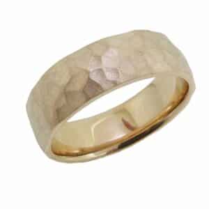 14K Yellow gold 7mm wide domed men's band with a hammered texture and a stainless finish. Available in 14K gold, 18K gold, or platinum. This ring can be made in any combination of white, pink or yellow gold and can be customized to different widths and finishes by special order.