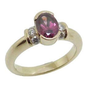 14K Yellow gold lady's ring semi-bezel set in the centre with a 1.017 carat oval rhodolite garnet and accented on each side with six round brilliant cut diamonds, 0.191 total carat weight, G/H, SI.