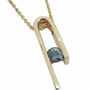 14K Yellow gold custom pendant by Studio Tzela channel set with a 0.392 carat teal sapphire.
