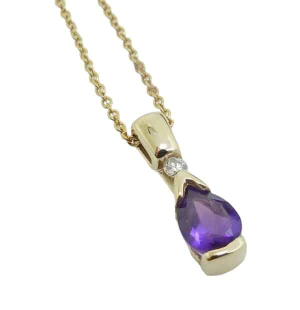 14K Yellow gold pendant set with one 7x5mm pear-shaped amethyst and one 0.04 carat round brilliant cut diamond, G/H, SI
