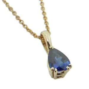 14K Yellow gold pendant claw set with a 0.57 carat pear shape blue sapphire.