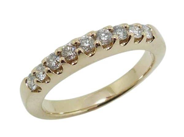14K Yellow gold lady's wedding band claw set with nine round brilliant cut natural diamonds totaling 0.226 carats, G-H, VS-SI.