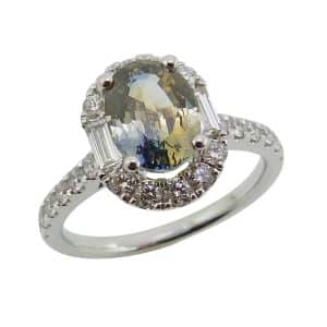 14K White gold halo lady's ring claw set in the centre with a 2.24 carat bi-colour sapphire and accented in the halo and on the band with round brilliant cut and baguette natural diamonds, 0.75cttw, F/G/H, VS-SI1.