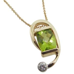 14K Yellow and white custom pendant channel and bezel set with a 1.97 carat peridot and a 0.115 carat natural, round brilliant cut diamond, H, I1.